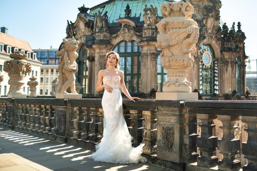 A bride in a white dress on a wedding walk at the famous Baroque Zwinger Palace in Dresden, Saxony, Germany.