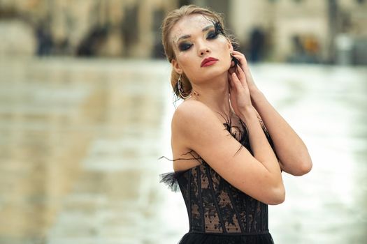 A stylish bride in a black wedding dress in the ancient French city of Avignon. A model in a black dress.