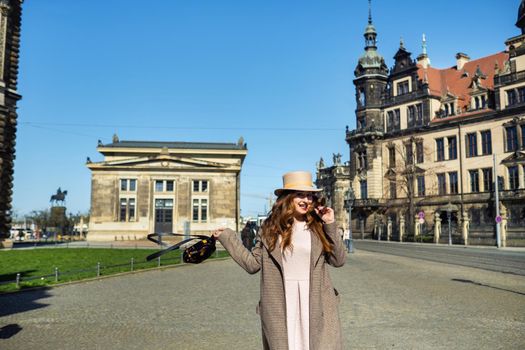 a girl in a coat and hat on a street in the city of Dresden. Saxon Switzerland, Germany.