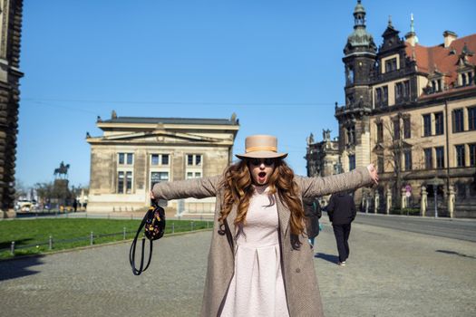 a girl in a coat and hat on a street in the city of Dresden. Saxon Switzerland, Germany.