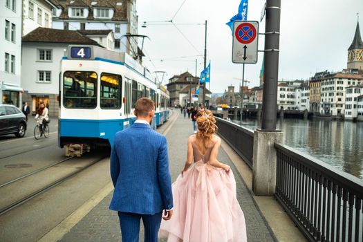 The bride and groom walk along the Limmat river embankment in the city center of Zurich.Switzerland.