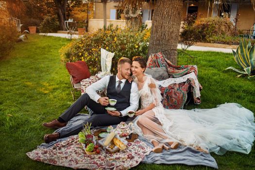 Newlyweds ' dinner on the lawn at sunset.A couple sits and drinks tea at sunset in France.