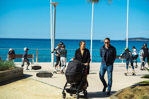 April 5, 2019. Saint-Cyr-sur-Mer, France.Happy Family with a stroller and Children on skateboards on the village embankment.