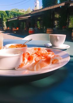 Breakfast outdoors in summer, ham, jam, butter and ham.