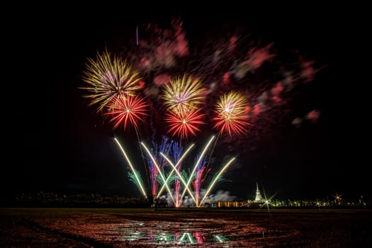 Huge, colorful fireworks over the rice fields at dusk.
