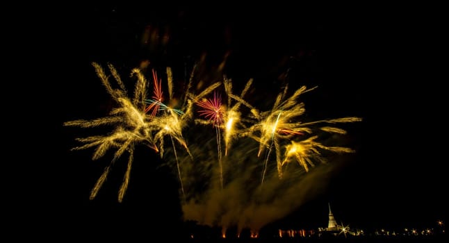 Huge, colorful fireworks over the rice fields at dusk.