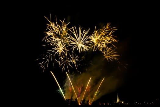 Huge, colorful fireworks over the rice fields at dusk.
