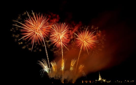 Huge, colorful fireworks over the rice fields at dusk.