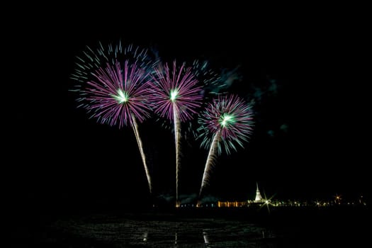 Huge, colorful fireworks over the rice fields at dusk.