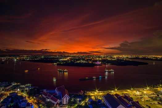 Bird's eye view of Samut Prakan, Thailand. Sunset over the Chao Phraya River, orange sky.