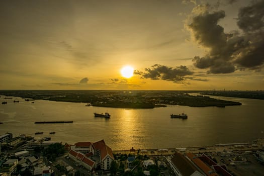 Bird's eye view of Samut Prakan, Thailand. Sunset over the Chao Phraya River, orange sky.