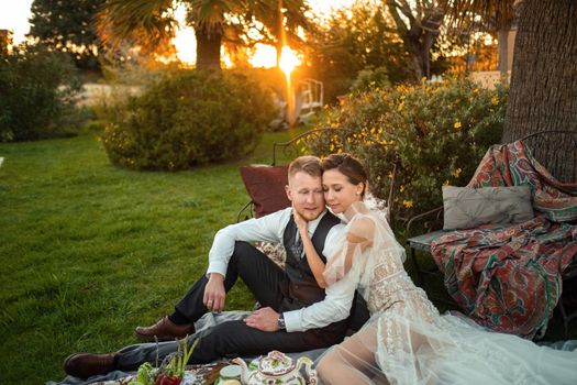 Newlyweds ' dinner on the lawn at sunset.A couple sits and drinks tea at sunset in France.