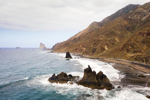 Rough rocky cliffs in the North of Tenerife. Beautiful Benijo beach in the Canary Islands. Rocks, volcanic rocks, Atlantic ocean.