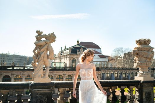 A bride in a white dress on a wedding walk at the famous Baroque Zwinger Palace in Dresden, Saxony, Germany.