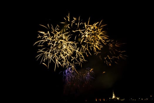 Huge, colorful fireworks over the rice fields at dusk.