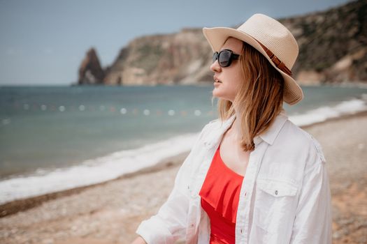 Young woman in red bikini on Beach. Blonde in sunglasses on pebble beach enjoying sun. Happy lady in one piece red swimsuit relaxing and sunbathing by turquoise sea ocean on hot summer day. Close up,