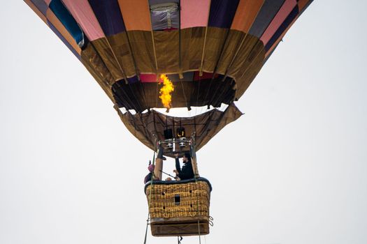 Close up shot of basket of Hot air balloon with fire heating air in wicker basket with himalaya mountains in background showing this adventure in kullu manali valley India