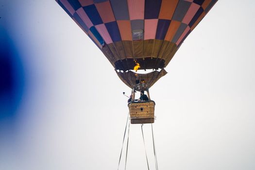 Close up shot of basket of Hot air balloon with fire heating air in wicker basket with himalaya mountains in background showing this adventure in kullu manali valley