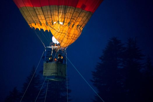 Close up shot of basket of Hot air balloon with fire heating air in wicker basket with himalaya mountains in background showing this adventure in kullu manali valley