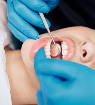 He is one thorough dentist. a woman having her teeth checked at the dentists office