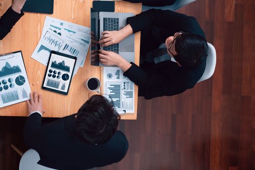 Top-view business team of financial data analysis meeting with business intelligence, report paper and dashboard on laptop for marketing strategy. Business people working together in office of harmony