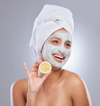 I cant go a day without Vitamin C. an attractive young woman wearing a face mask and holding a lemon in the studio