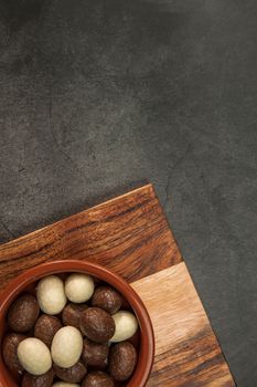 Chocolate easter eggs, candies on concrete background. Horizontal orientation, place for copyspace, flatlay, top view. Happy Easter concept dark design