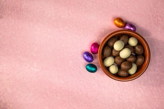Easter. Composition with chocolate Easter eggs on pink background, space for text. top view Happy Easter holiday candy