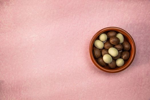 Easter. Composition with chocolate Easter eggs on pink background, space for text. top view Happy Easter holiday candy