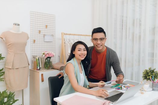 Photo of cheerful woman and man designers working in the studio