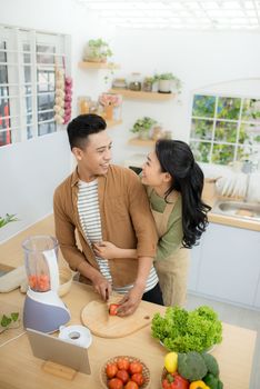 Young Asian couple. Standing cooking in the kitchen. 