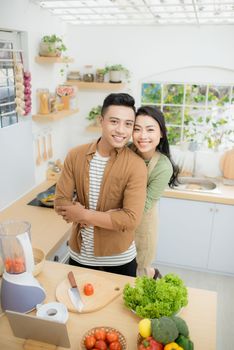 young asian couple cooking in kitchen