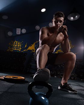 Muscular man showing muscles isolated on the wall background. Strong male naked torso abs, creative photo, beautiful body, physique, relief, sexy guy, young.