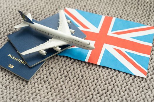 Tourim flight to the Grean Britain concept. Vacation in the United Kingdom. Composition of the UK flag, passport and toy airplane
