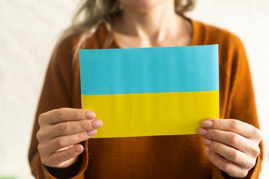 Ukrainian flag in hands. The concept of ending the war in Ukraine