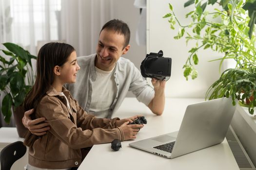 Little girl having fun time with her father using VR glasses at home for learning molecular structure. Homeschooling concept. Modern technology using by family.
