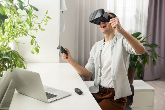 a man in a jacket is studying a new profession. A VR programmer plays a virtual reality game at home. favorite hobby he wore a helmet on his head in black for.