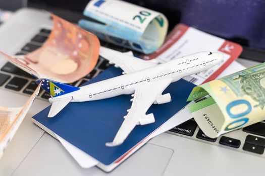 Composition with laptop, toy plane and money on color background. Travel agency.
