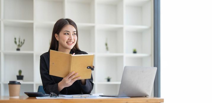 Asian businesswoman meeting at the office, taking notes and using a tablet at the office...