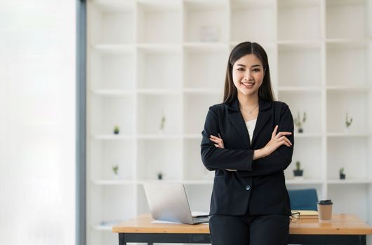 Beautiful Asian businesswoman crossed arms at the office looking at the camera...