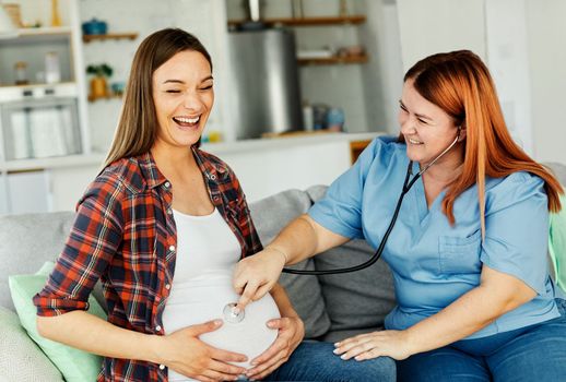 Portrait of a young happy pregnant woman doing exam with doctor or nurse during a visit at home or in a clinic