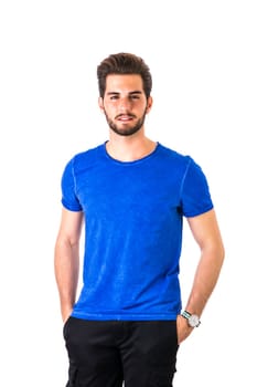 Handsome young man standing with blue shirt, half body shot, with hands in pockets