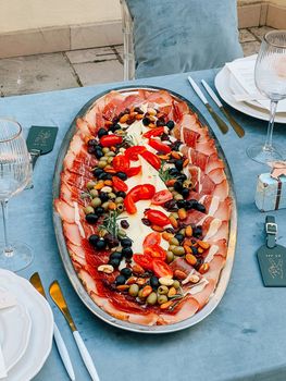 Dish with meat and cheese cuts is on the table. High quality photo