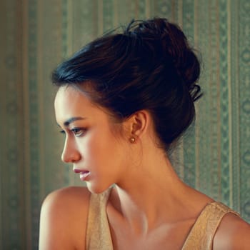 Sensual beauty of another era. Profile shot of a beautiful young woman dressed elegantly indoors