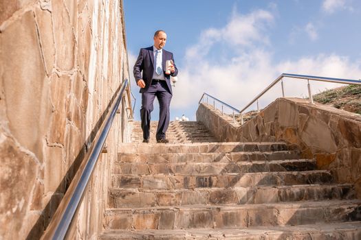 Business executive with briefcase going down the stairs.