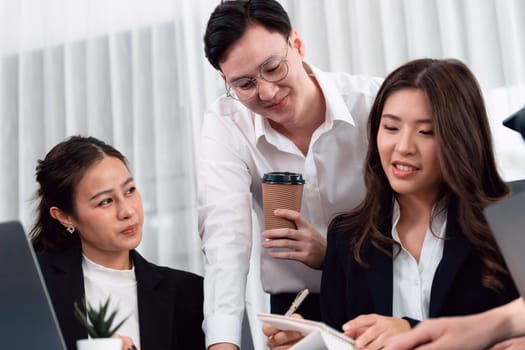 Harmony in office concept as business people analyzing dashboard paper together in workplace. Young colleagues give ideas at manager desk for discussion or strategy planning about project.
