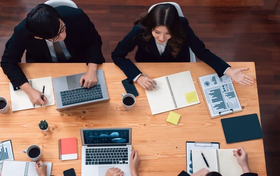 Top-view business team of financial data analysis meeting with business intelligence, report paper and dashboard on laptop for marketing strategy. Business people working together in office of harmony