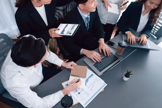 Harmony in office concept as business people analyzing dashboard paper together in workplace. Young colleagues give ideas at manager desk for discussion or strategy planning about project.
