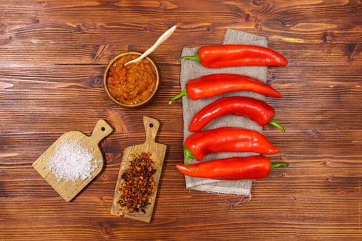 Ajvar from sweet peppers, eggplant, tomatoes, garlic and onions with spices wooden table. Balkan food. Flat lay