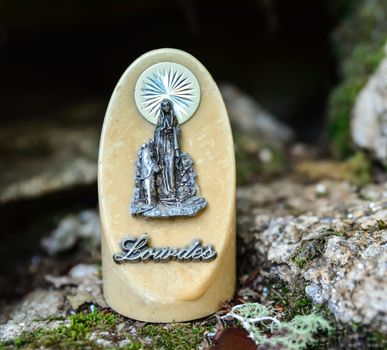 The statue of Our Lady of Lourdes on ivory stone